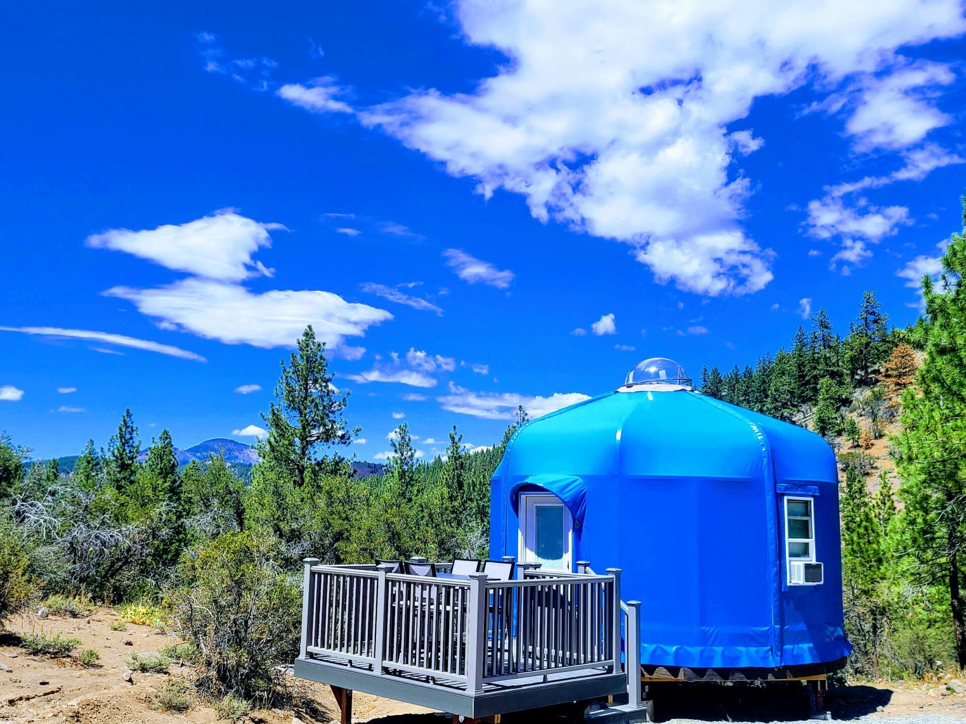 The High Camp yurt — bright blue dome with private deck and mountain views