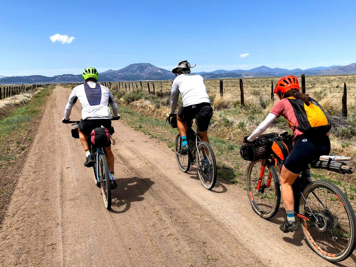 Gravel riders on an open road through Sierra Valley near Beckwourth Peak High Camp