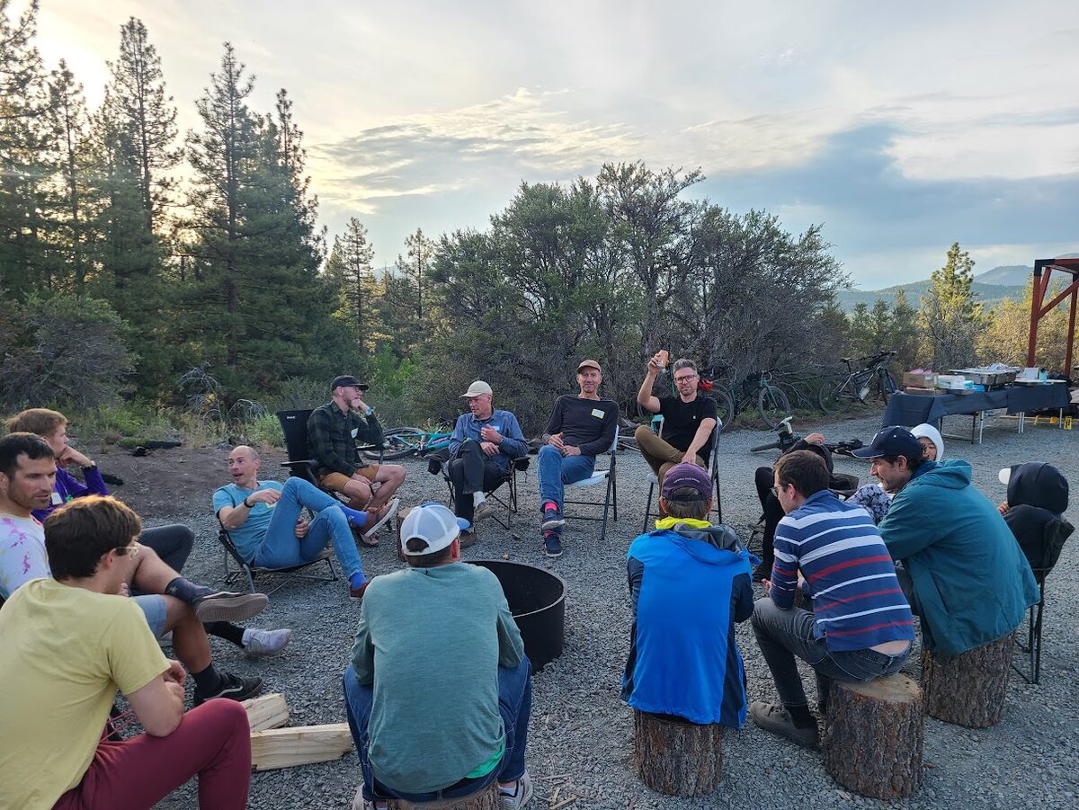 Mountain bikers gathered in a circle around the fire pit at Beckwourth Peak High Camp